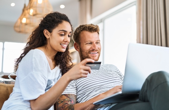 Couple with a credit card and laptop.