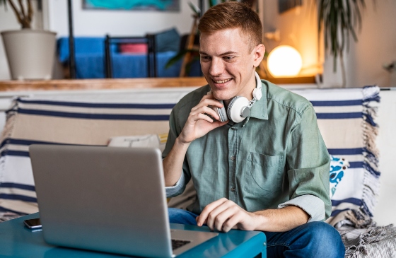 Young man smiling and using his laptop.