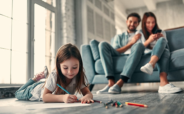 Girl coloring while parents watch