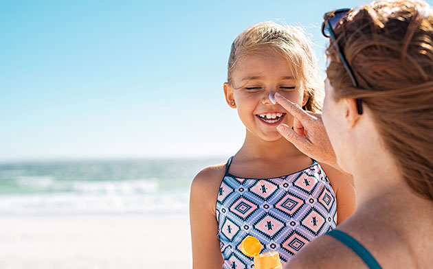 Applying sunscreen at the beach on a sunny day. 