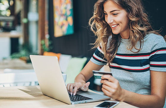 Younger lady using her laptop to do digital banking.