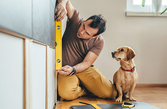 Man sitting with his dog making home improvements.