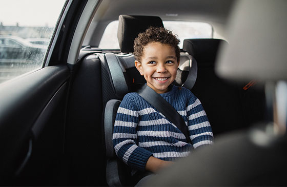 Cute kid riding in a car seat.