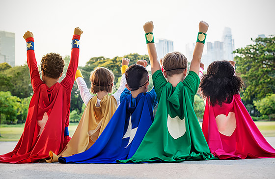 Kids sitting with superhero costumes on