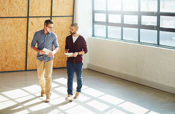 Two men walking in an empty building