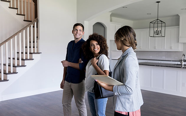 Man and woman talking to a realtor about buying their first house. 