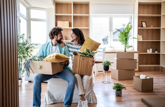 Couple sitting with boxes, moving into their home.