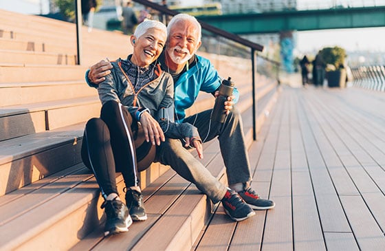 Elderly couple sits on steps.