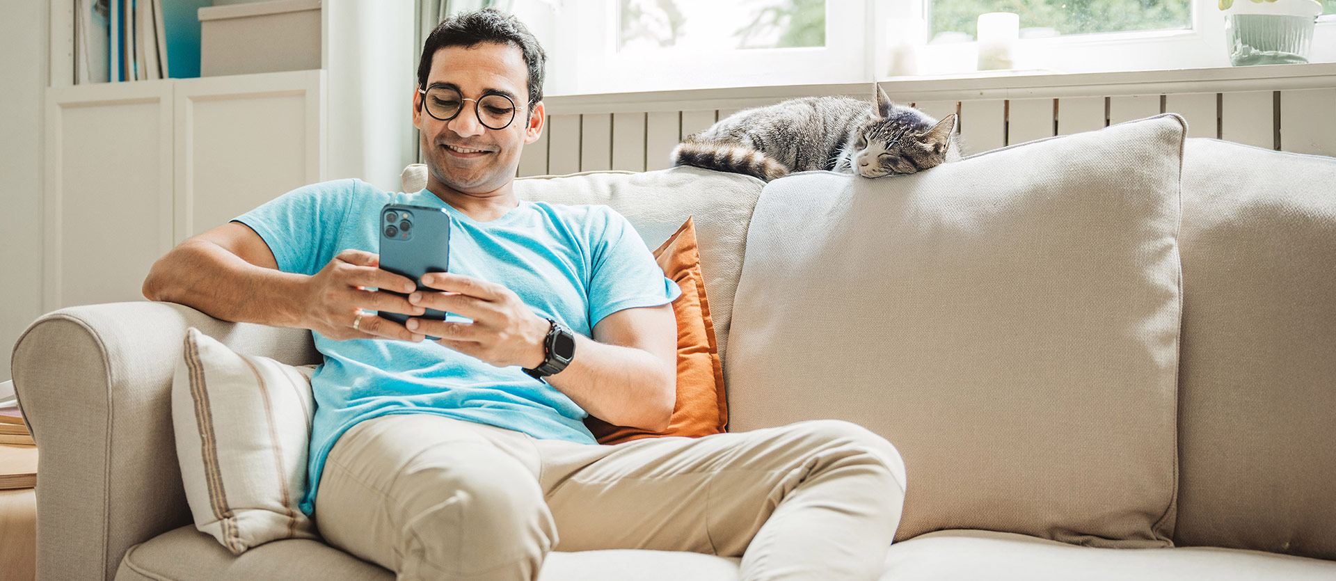 Man sitting on the couch looking at his phone. 