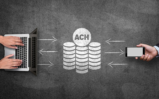 A laptop and mobile phone making an ACH transfer. 