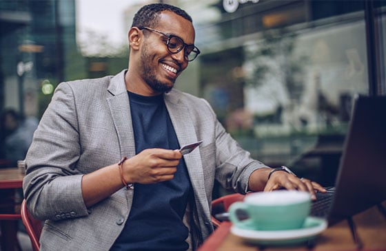 Young man smiling with a credit card