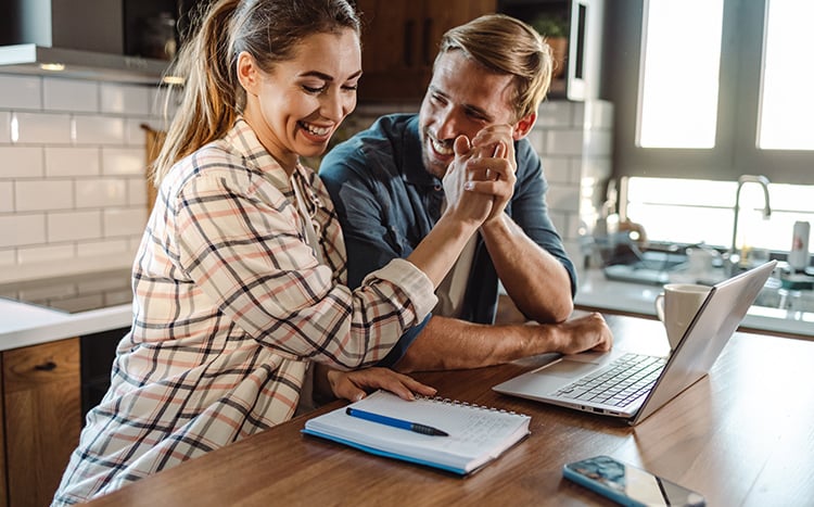 Young couple high-fiving while working on budget