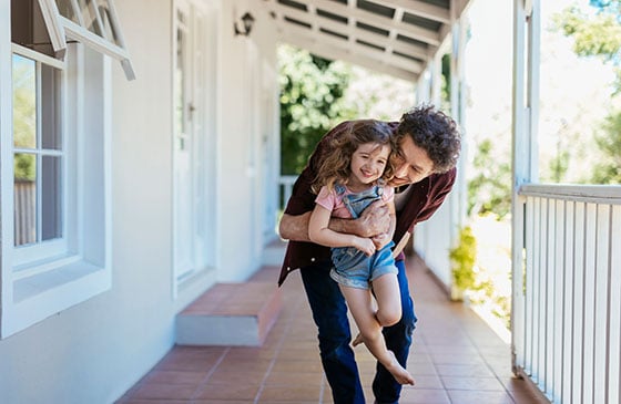 Dad and daughter having fun on the porch of their house. 