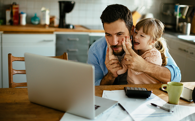 Father and daughter sitting in front of laptop
