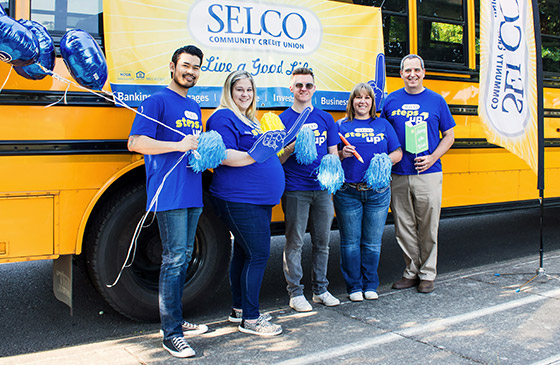 SELCO employees standing in front of a bus. 