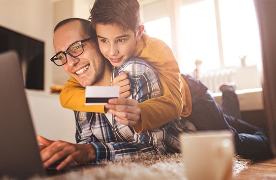 Boy with credit card hugging his dad