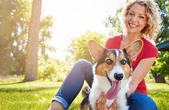 Women sitting outside with her dog in the sun