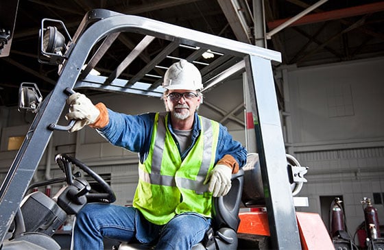 Employee driving new forklift equipment purchased with a business loan