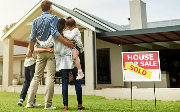 Young family looking at their home after it sold.