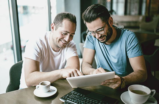 Two men looking at joint banking account on iPad