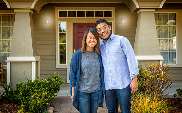 Couple standing in front of house