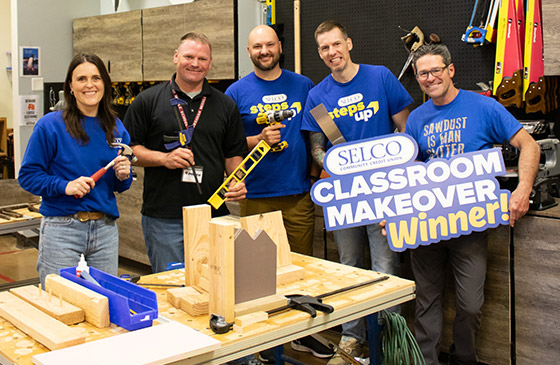 Obsidian Middle School staff and supporters in a hands-on woodworking classroom after winning a SELCO Classroom Makeover grant.