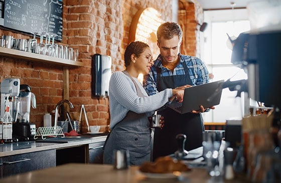 Man and woman in restaurant looking at laptop