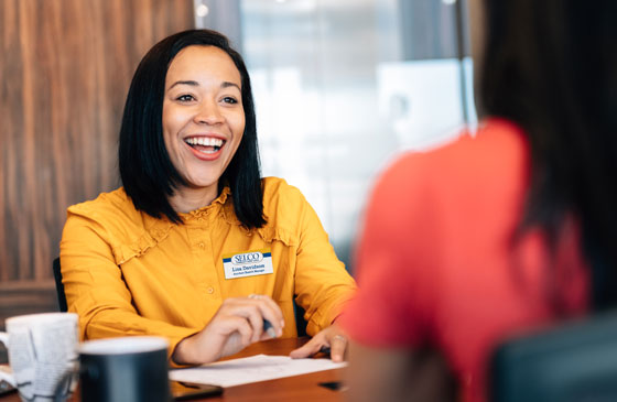 SELCO team member smiling and working with a member.