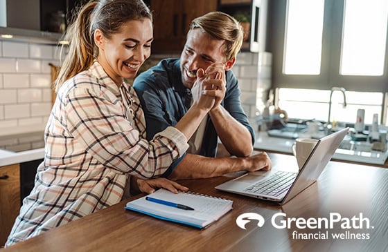 Couple getting each other a high five while budgeting