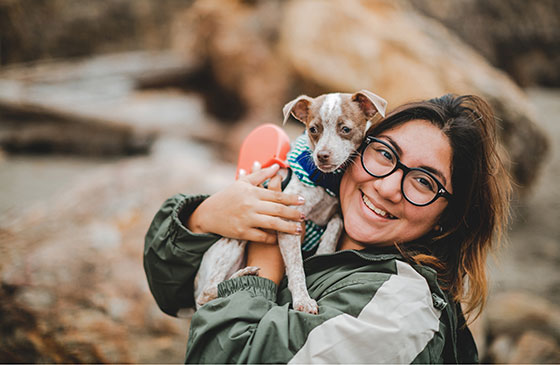 Image of a lady holding her dog. 