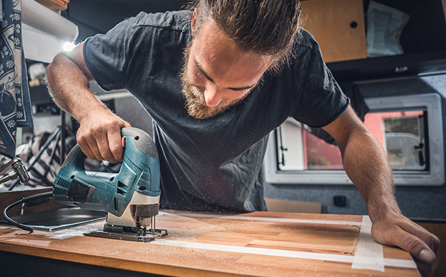 Man using a skill saw inside an RV