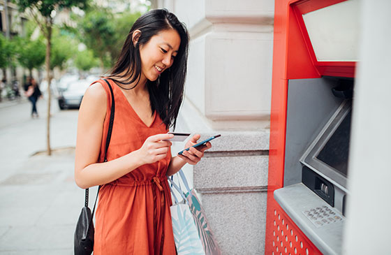 Younger women accessing her savings account near ATM