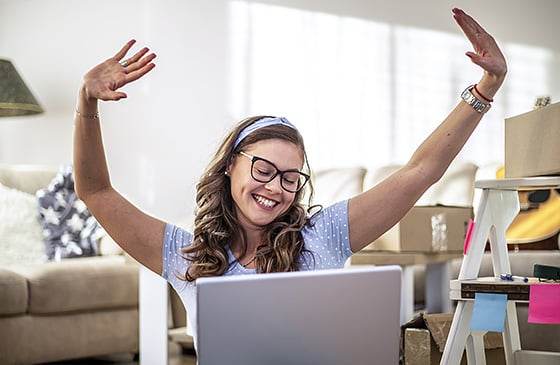 Woman celebrating being able to skip a payment to catch up on her bills from the Holiday season. 