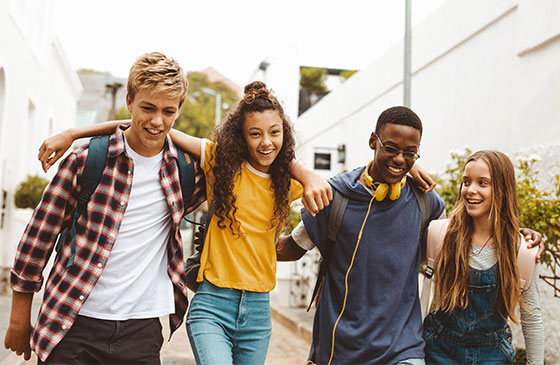 Group of happy high school students walking together