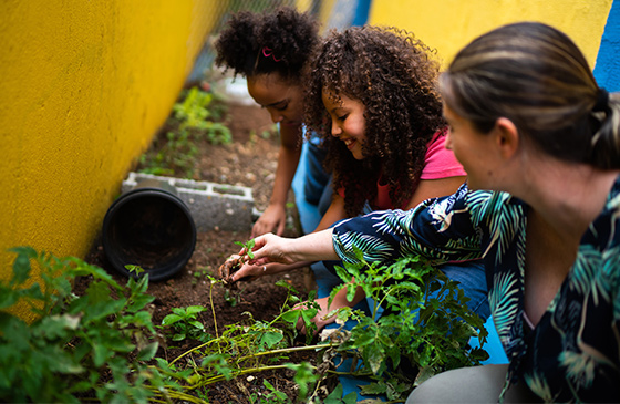 Teacher and kids learning how to garden with the help from a SELCO classroom makeover grant. 